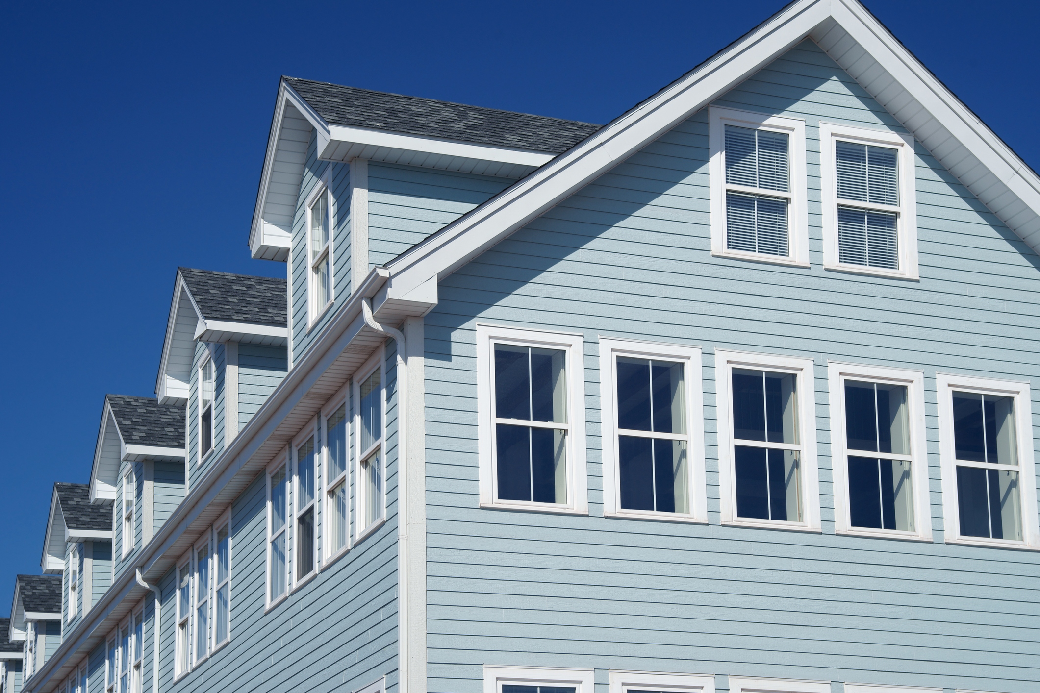 Newly installed light blue siding on multi-story residential home