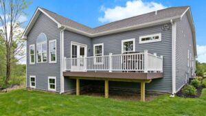 Home featuring installed siding and a spacious backyard deck