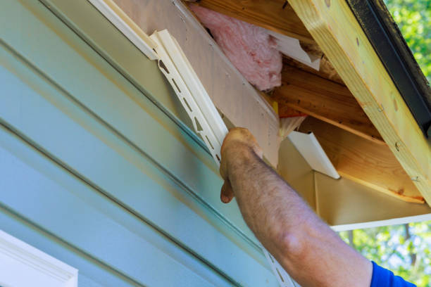 Worker replacing residential siding with vinyl material on the exterior
