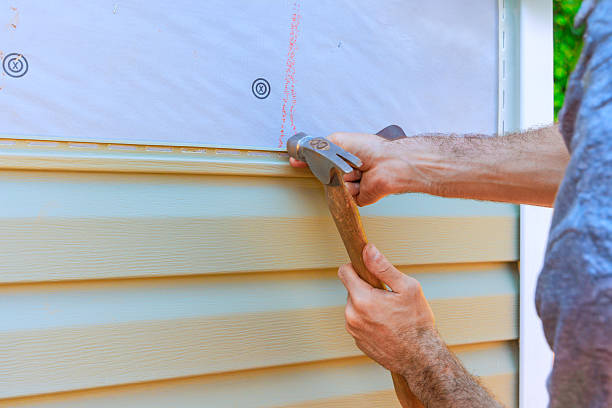 Close-up of a worker's hands installing vinyl siding on a home's exterior