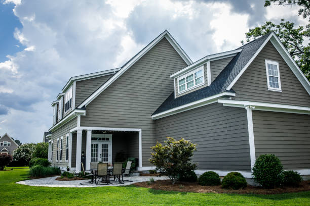 A home with newly installed gray vinyl siding and a patio area