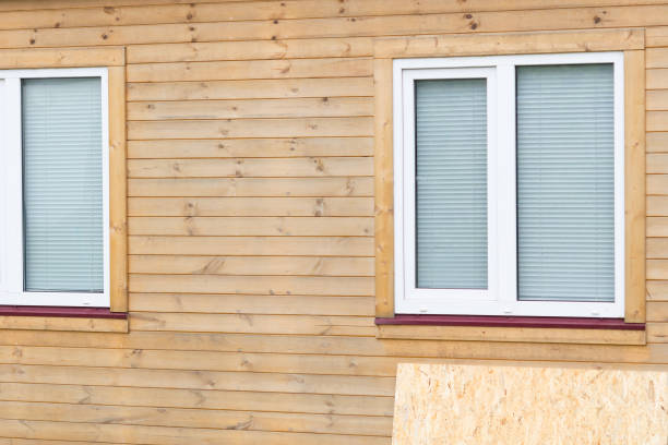 Freshly installed wood siding on a residential home with windows