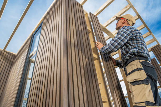 Professional installing engineered wood siding on a new home structure