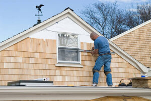 Professional siding installer working on engineered wood siding